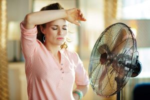 a woman in front of a fan on a hot day